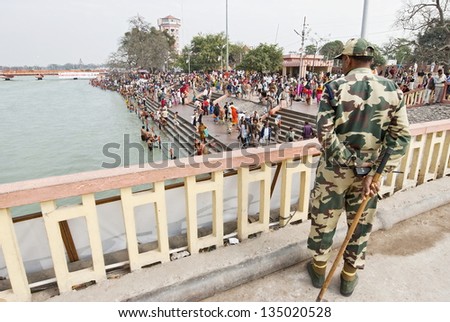 HARIDWAR, INDIA - FEBRUARY 12: Unidentified security man oversees security during celebration Kumbha Mela, February 12, 2010 in Haridwar, India. Security issue is main problem on major Hindu festival.