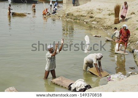 VARANASI, INDIA - APRIL 30: Unidentified Indian people wash clothes in Ganga river on April 30, 2009 in Varanasi, India. For many dwellers of Varanasi the Ganga is only way to wash clothes.