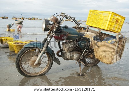 MUI NE, VIETNAM - NOVEMBER 3: Old motorcycle made in Soviet Union waits loading on the beach in Mui Ne, Vietnam on November 3, 2008. Even 20-year-old Soviet vehicles is still used in Vietnam.