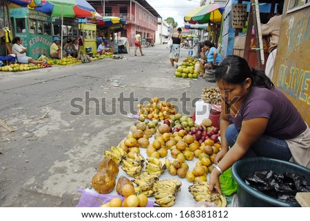 IQUITOS, PERU - APRIL 30: Unidentified Peruvian woman sells exotic fruits on a street of Iquitos, Peru on April 30, 2010. Amazon Peru is known for the rich variety of exotic fruits unknown beyond.