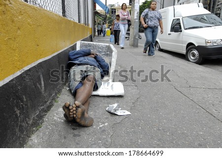 SAO PAULO, BRAZIL - MAY 17: Unidentified homeless man sleeps on a street in Sao Paolo, Brazil. Homelessness is one of the main social issues in metropolitan areas in Brazil.