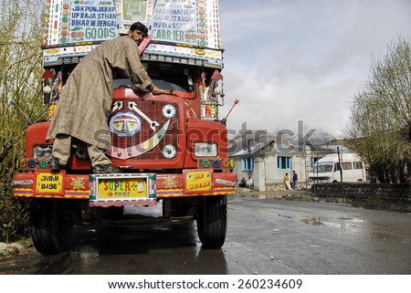 KASHMIR, INDIA - MAY 20: Unidentified Indian driver washes his truck on a Srinagar - Leh road, India, on May 20, 2009. Trucks are traditionally brightly decorated in India.