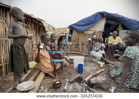 JUBA, SOUTH SUDAN - FEBRUARY 28: Unidentified people have breakfast in front of their huts in displaced persons camp, Juba, South Sudan, February 28, 2012. They stay in harsh conditions for long time.