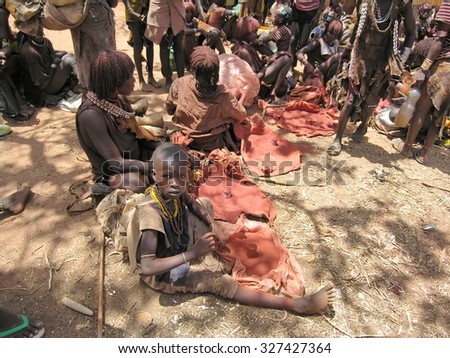 OMO VALLEY, ETHIOPIA - MARCH 13: Unidentified Hamer women sell ochre at market in Dimeka, March 13, 2012, Omo Valley, Ethiopia. Ochre is a natural earth pigment used by Hamer women to make hairdress.