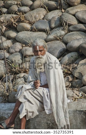 HARIDWAR, INDIA - FEBRUARY 12: Unidentified Indian sadhu (holy man) takes a rest by a stone wall during Kumbha Mela, February 12, 2010, Haridwar, India. Kumbha Mela is major Hindu festival in India.