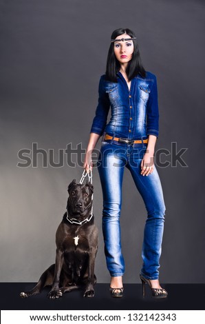 Beautiful young woman in jeans clothes  standing next to a dog