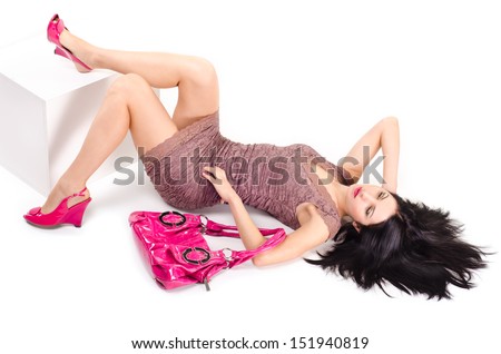 Girl lying on the floor with disheveled hair and keeps on hand bag