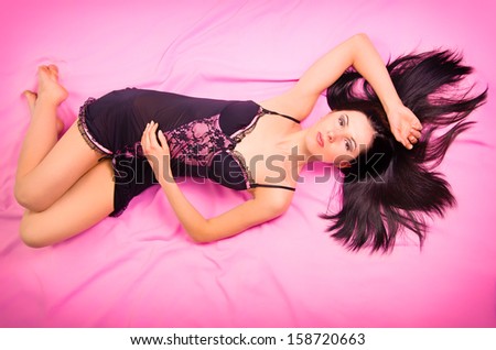 Beautiful sexy young woman lying in nightgown