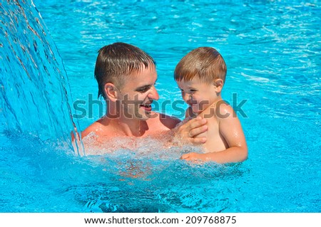 Father and son having fun in the pool