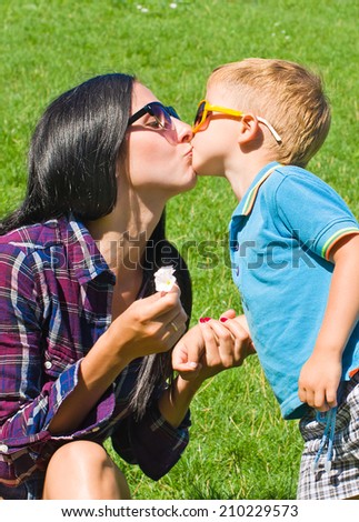 Portrait of mother and son kissing outdoors
