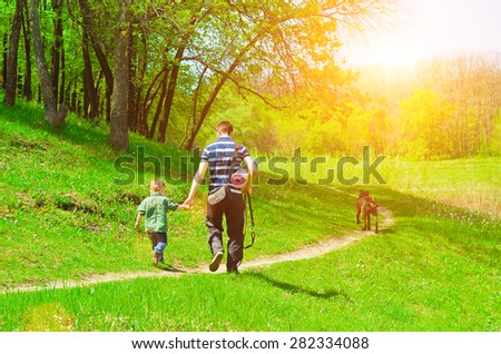 Father, son and dog for a walk in the woods