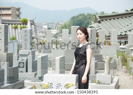 Japanese lady with black clothes pray at the grave