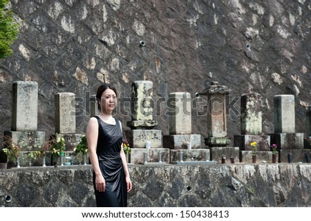 Japanese lady with black clothes pray at the grave