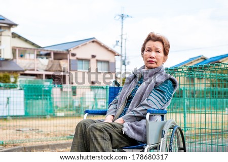 Private house and an elderly woman riding a wheelchair