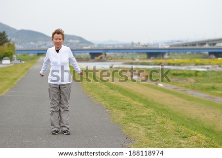 Women of Asian elderly Warming and jogging on the road to the river bank holiday