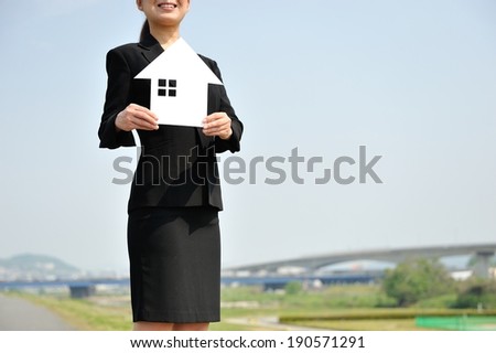 Businessmen suit standing back the blue sky with a house made ??of white paper