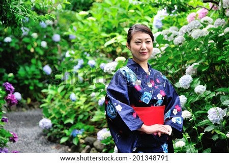 Beautiful Japanese woman standing in the garden blooming hydrangea wearing a kimono