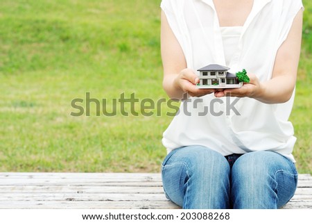 Women white shirt that has a model of the house