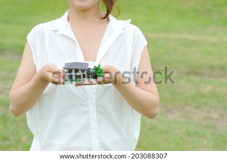 Women white shirt that has a model of the house