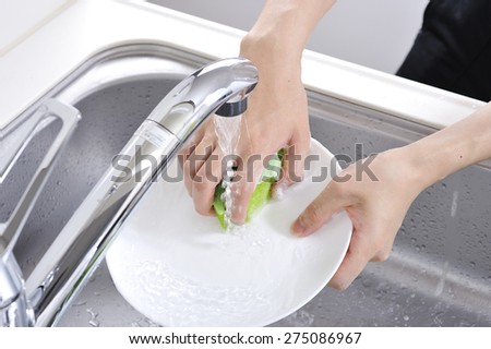 Wash the dishes in the kitchen