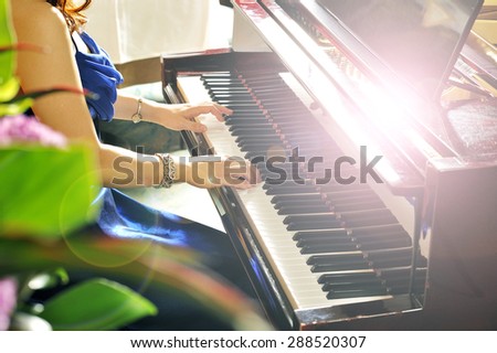 Women playing the grand piano in the room
