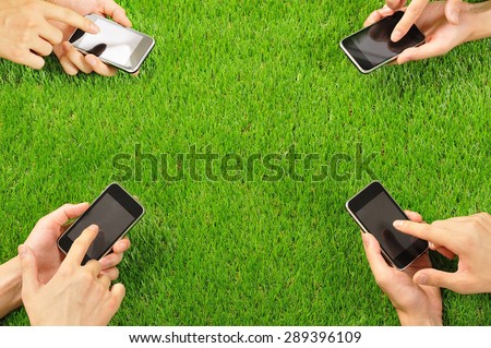 Hand to operate the smart phone,green grass