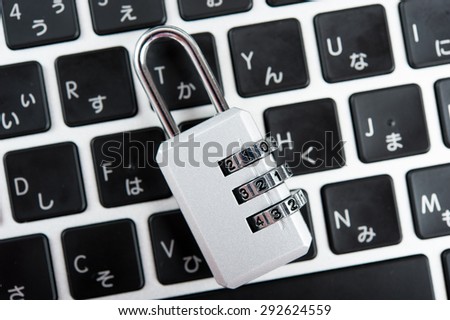 Laptop and silver key, pink background