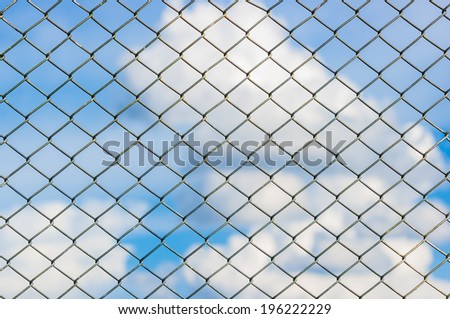 Metal mesh wire fence with blur cloud and blue sky background