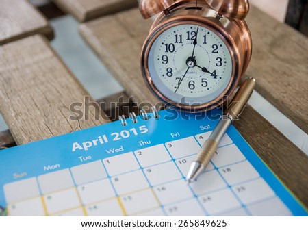 Alarm clock and calendar on wood background