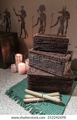 Wicker box with candles and bundles near the Egyptian drawings