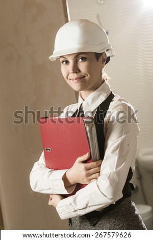 Girl in a helmet with a red folder of documents for real estate
