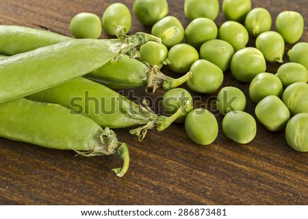 peas, pea pods next to a wooden table