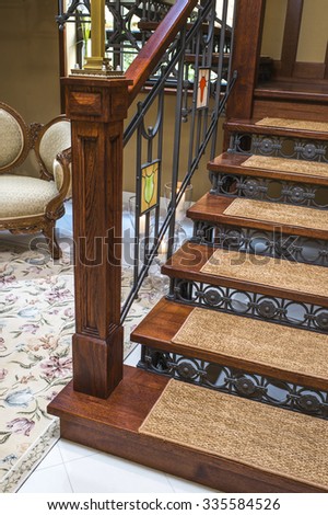 wooden staircase with wrought iron railing