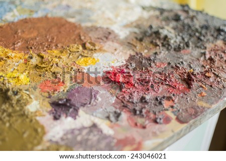 Corner of plank as painting palette with dry oil paint