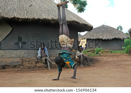 GULU, UGANDA, AFRICA - CIRCA MAY 2005:  Unidentified boy entertains village with a walking handstand circa May 2005 in Uganda, Africa.