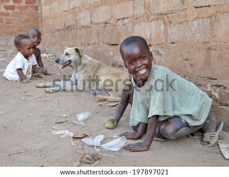 KAMPALA, UGANDA, AFRICA - CIRCA FEBRUARY 2009: Unidentified children and a dog living in the Kampala slums circa February 2009 in Uganda, Africa. Kampala is the largest city and capital of Uganda.