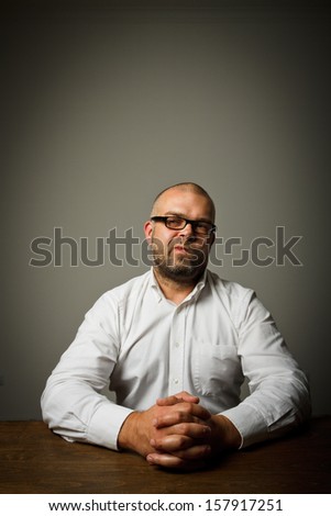Man in white sitting at the table expressing his feelings and emotions.