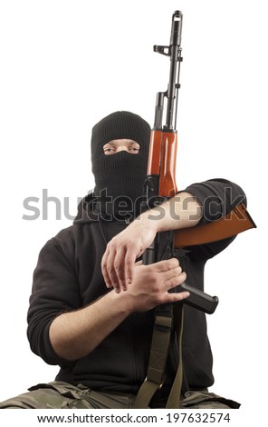 Man in mask with gun on light background