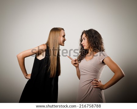Two young women are arguing about something. Young women are doing something.