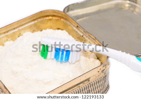 Soviet tooth powder in an iron pot and a toothbrush isolated on white background
