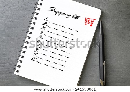 Shopping list written on notebook, grey wooden background.