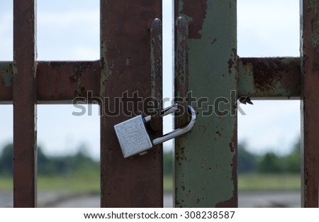 Gate with padlock with out of focus background