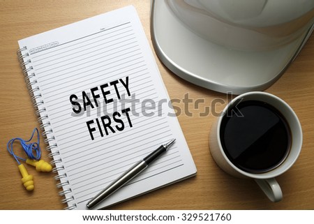 Safety quotes/slogan written on notebook, promoting good safety practices at workplace - business conceptual.