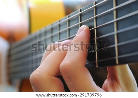 hand holding a chord on the guitar fretboard