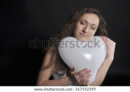 Young girl hugging a balloon as a heart