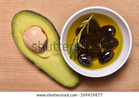 avocado and black olives on a wooden background