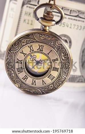 pocket watch and dollars on background