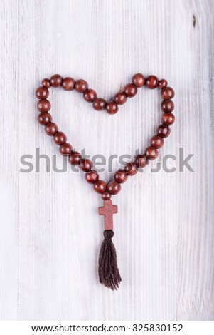 religious theme prayer beads and cross on white wooden background
