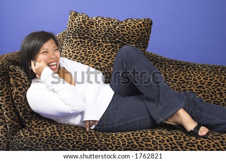 girl having happy talk on couch over blue background