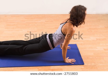 woman doing yoga on blue mat in studio